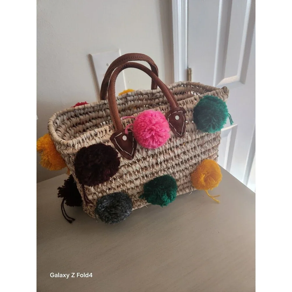 Beautiful woven straw bag with colorful pom-poms